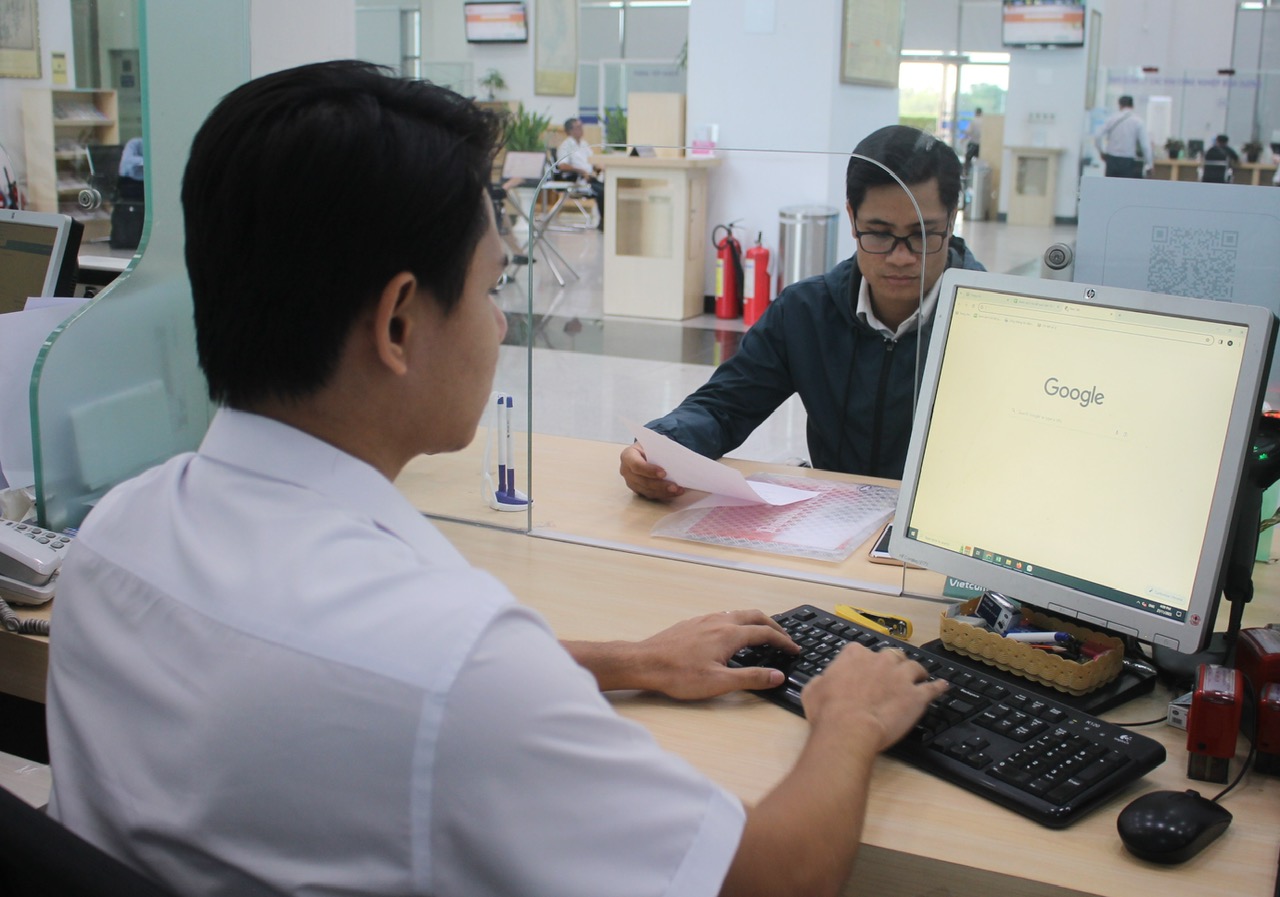 Cán bộ Sở Kế hoạch - Đầu tư giải quyết thủ tục hành chính cho doanh nghiệp chiều 27-11 (Ảnh: Hồ Văn).